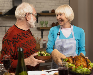 Elderly married couple looking at each other in the kitchen