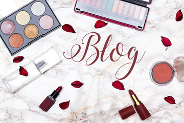 eye shadow and highlighter palette, perfume bottle, lipstick and blush on marble background, blog...