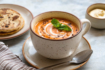 red lentil soup with bread and sour cream on white marble background. Homemade red lentil soup puree and flatbread. Healthy eating.