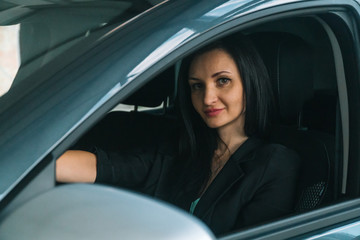Fototapeta na wymiar Woman wearing smart casual wear sits in car interior