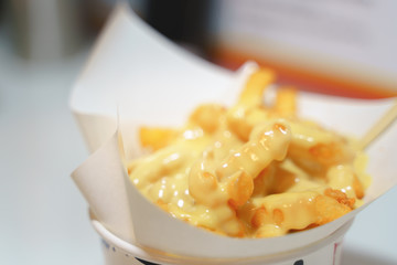 Eating french fries with melted cheddar cheese