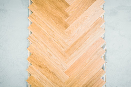 wooden floor background - herringbone parquet background with glue and stone underground