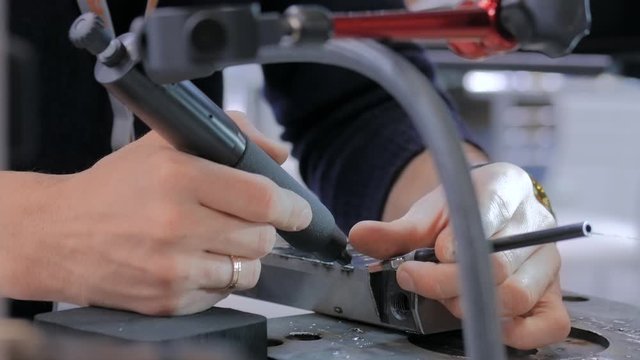 Professional male welder trying to work with gas tungsten arc welding GTAW or tungsten inert gas TIG technology at exhibition or trade show - close up view. Industrial concept and engineering work