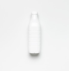 White plastic bottle containers for dairy products on light gray background top view flat lay. Plastic Kefir Yogurt Milk Bottle. Packaging template mockup. Layout for your design