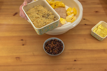 On a wooden table are all the ingredients for a Christmas stollen. These are given in a bowl. Concept: Christmas and baking