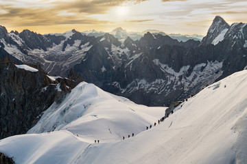 Climbers chain on a snowy mountainside of Mont Blanc Massif