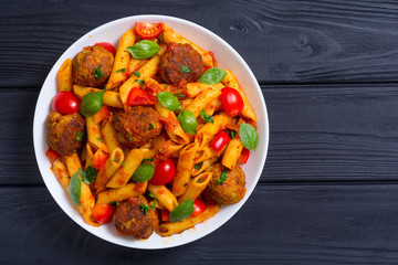 Italian penne pasta with meatballs and tomatoes