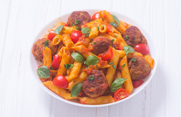 Italian penne pasta with meatballs and tomatoes