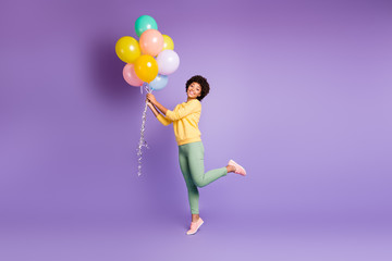 Fototapeta na wymiar Full length photo of positive afro american girl hold baloon present for woman day feel content have autumn holiday walk with boyfriend wear stylish outfit isolated violet purple color background