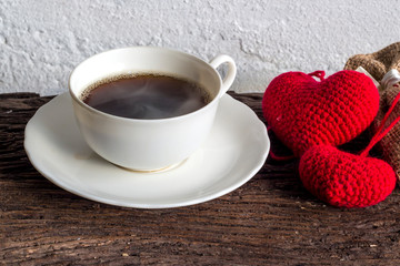 Coffee on old wood with red hearts