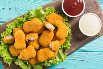 Chicken nuggets in plate on rustic background