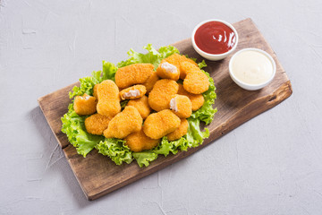 Chicken nuggets in plate on rustic background