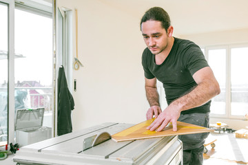 Handwerker schneidet parkett mit Kreissäge in einem neubau haus