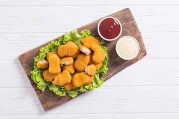 Chicken nuggets in plate on rustic background