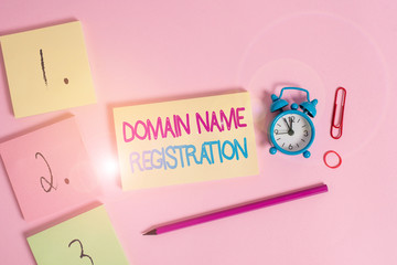 Writing note showing Domain Name Registration. Business concept for Own an IP Address Identify a particular Webpage Blank notepads marker rubber band alarm clock clip colored background