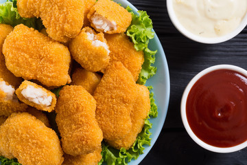 Chicken nuggets in plate on rustic background