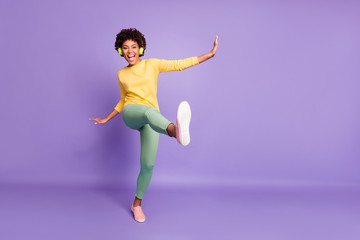Fototapeta na wymiar Full length body size photo of wavy cheerful excited ecstatic overjoyed shouting girlfriend dancing listening to music pretending to be kicking with leg near empty space isolated over violet color