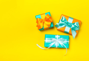 Set of attractive gifts on the yellow background. Trendy orange and green colors. Merry Christmas, St. Valentine's Day, Happy Birthday and other holidays concept. Copy space. Flat lay
