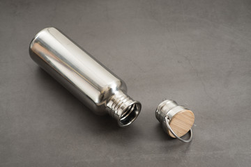 Durable, high quality reusable stainless steel bottle on gray background as alternative to plastic bottles. Toxin, BPA, plastic free zero waste option for drinking tap water at home or at the office.