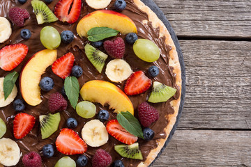Fruit pizza with nut nougat cream , fruit and berries