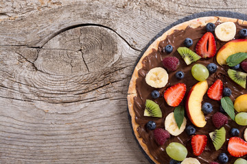 Fruit pizza with nut nougat cream , fruit and berries
