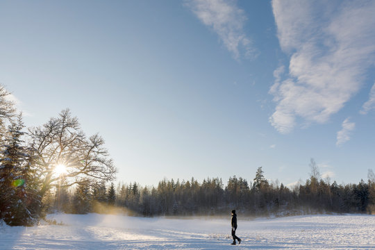 Mature woman walking through the snow in Ostergotland, Sweden
