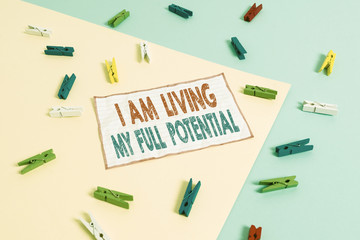 Conceptual hand writing showing I Am Living My Full Potential. Concept meaning Embracing opportunities using skills abilities Colored clothespin paper reminder with yellow blue background