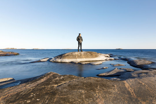 Man standing on rock by sea