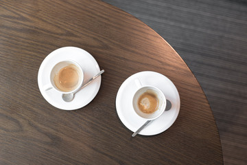 Top view of two empty and dirty coffee cups at the office conference table.