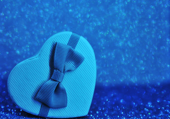 Gift heart box on sparkling glitter paper background. 