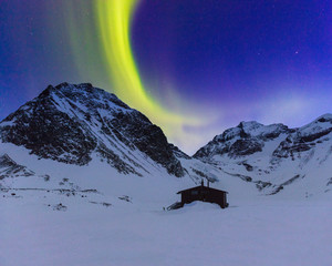 Northern lights over snow covered mountains in Lapland, Sweden