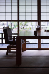 Traditional Japanese restaurant environment, shoji windows and doors, wooden tables and chairs.