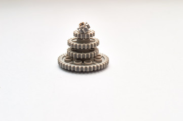 pyramid of gray toy gear wheels representing team work on the paper background