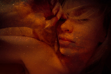 Blurred image of sleeping young women in the night universe. Tinted dark orange starry space