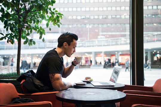 Man using laptop in cafe