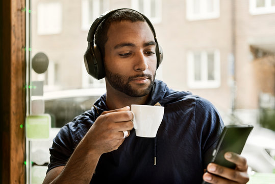 Young man listening to music in cafe