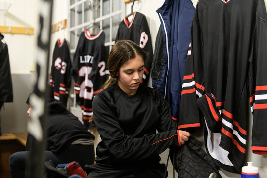 Girl in changing room prepares for ice hockey training