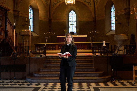 Priest with bible in church