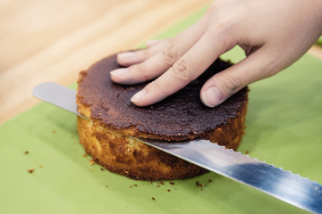 Making a layer cake. Cutting the top off of cakes with a serrated knife to level cake.