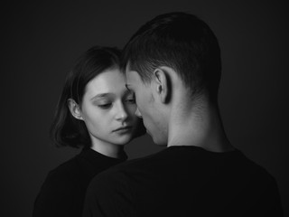 Young couple posing in studio. Low key. Black and white