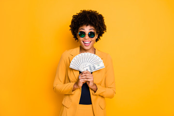Portrait of excited afro american lady freelancer hold money fan get salary profit income scream...