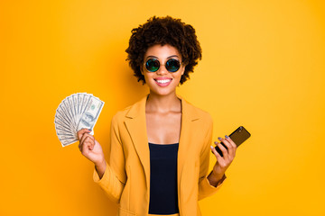 Portrait of positive cheerful afro american lady freelancer get cashback salary hold money fan use...