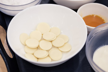 White chocolate chips in a bowl for melting, preparing ingredients to make a cake.