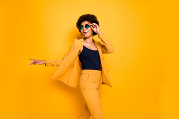 Portrait of positive cheerful lady feel candid expression enjoy rest relax on free time wear stylish fashionable clothes isolated over yellow color background - obrazy, fototapety, plakaty