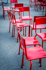 Dettaglio di alcune sedie rosse nel giardino di un bar