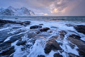 Coast of Norwegian sea on rocky coast in fjord on sunset