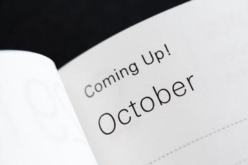 Coming Up! October, months of a year. Macro shot of a monthly planner.