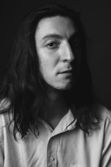 Portrait of young man with long hair. Black and white. Close up.