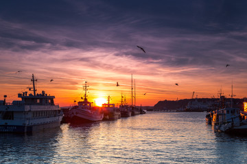 Fishing boats in harbor of Sassnitz at ruegen island. The sun sets in the background, Sassnitz, Ruegen Island