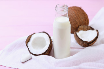 Milk and broken coconuts on the table. Vegetable milk, a veggie drink.
